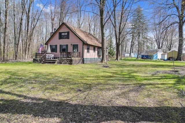 back of house featuring a lawn and a deck