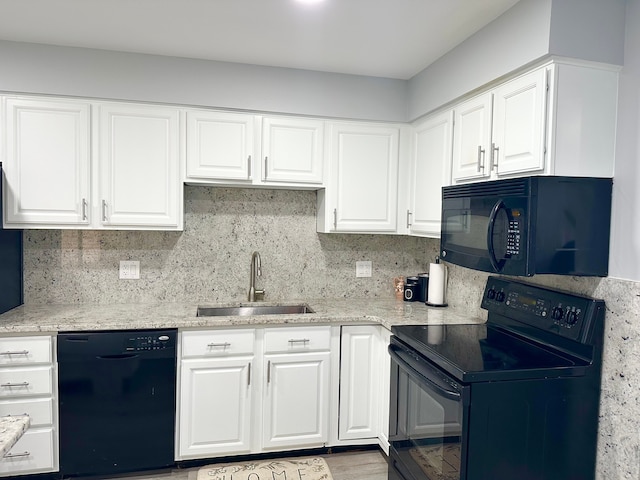 kitchen featuring black appliances, backsplash, white cabinets, and a sink