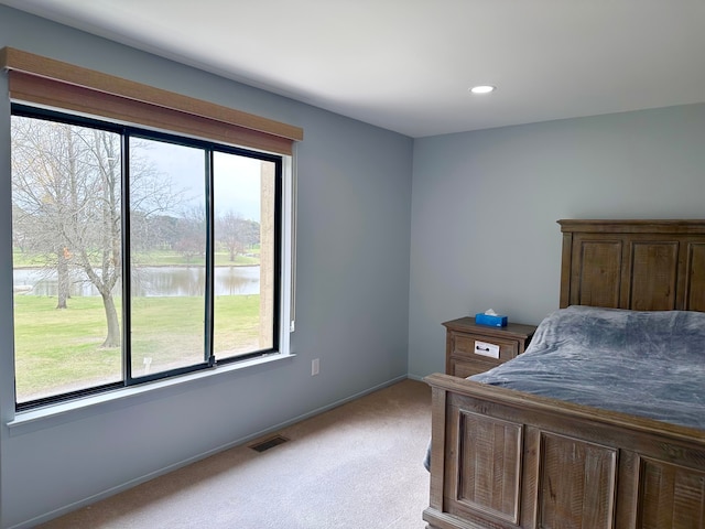 bedroom with carpet flooring, visible vents, a water view, baseboards, and recessed lighting