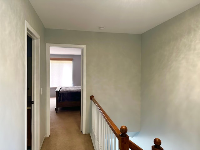 hall featuring an upstairs landing and carpet floors