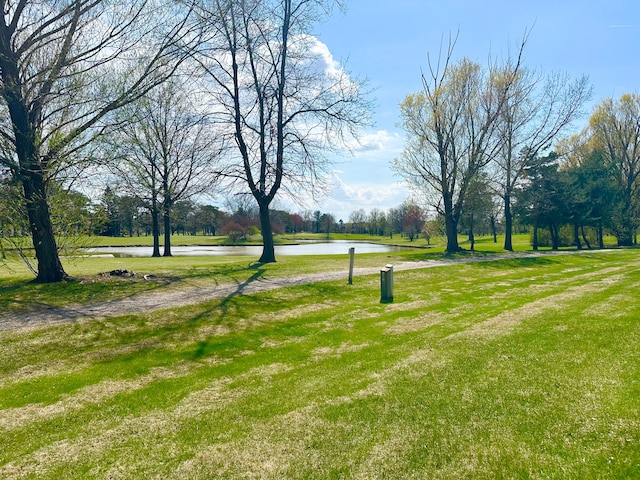view of property's community with a lawn and a water view