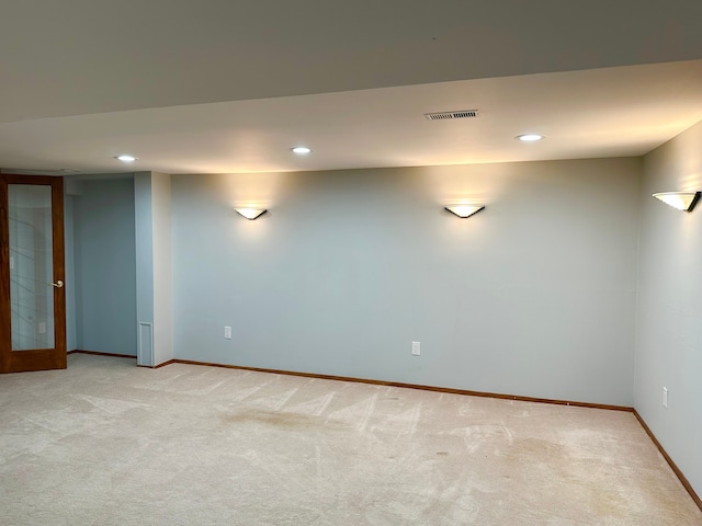 spare room with visible vents, light carpet, and baseboards
