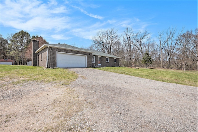 ranch-style home featuring a chimney, gravel driveway, an attached garage, a front lawn, and brick siding