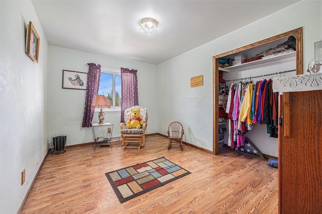 living area with baseboards and wood finished floors