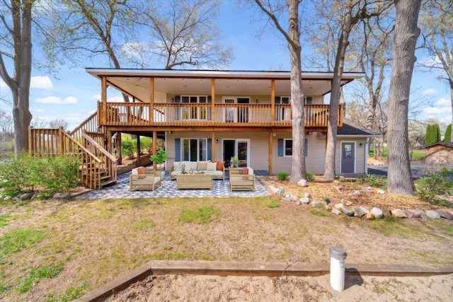 rear view of property featuring an outdoor living space, stairway, a deck, and a patio