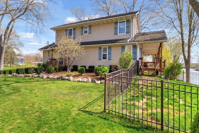 back of house with a lawn and fence