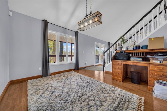 interior space featuring baseboards, wood finished floors, and stairway