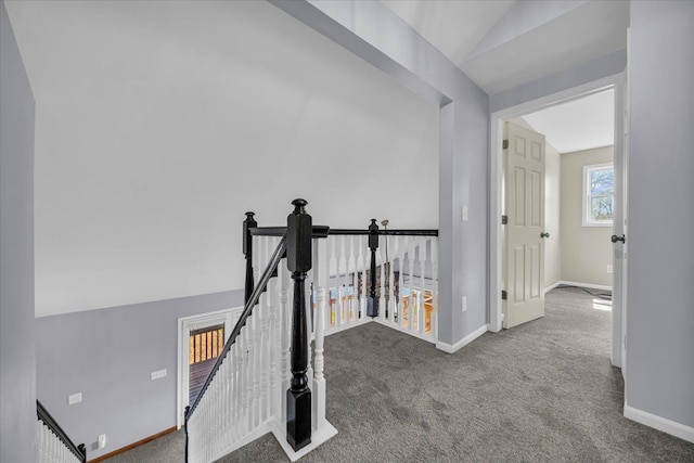 hallway with baseboards, carpet flooring, and an upstairs landing