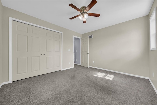 unfurnished bedroom featuring carpet floors, a ceiling fan, baseboards, visible vents, and a closet