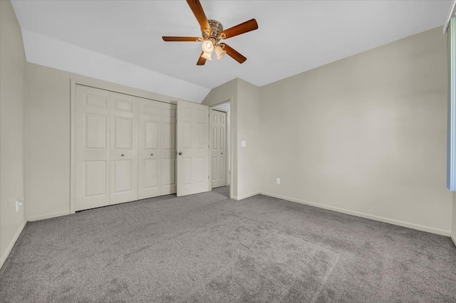 unfurnished bedroom featuring carpet floors, baseboards, and vaulted ceiling
