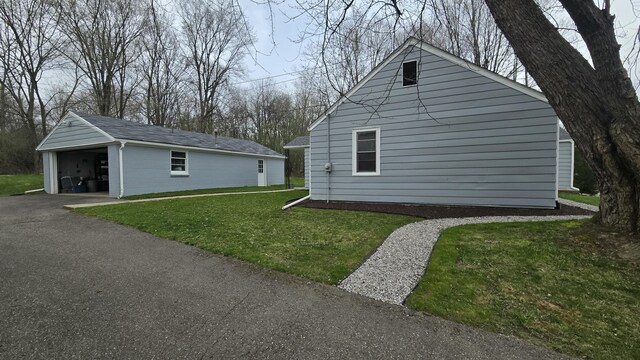 view of side of home with an outbuilding, a lawn, and a garage