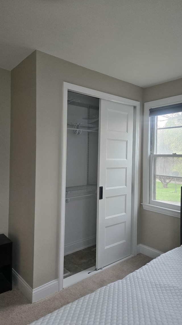 unfurnished bedroom featuring a closet, carpet floors, and baseboards