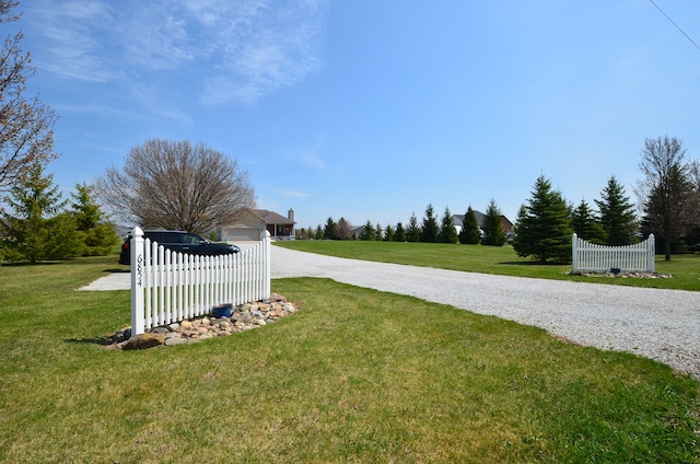 view of yard featuring driveway and fence