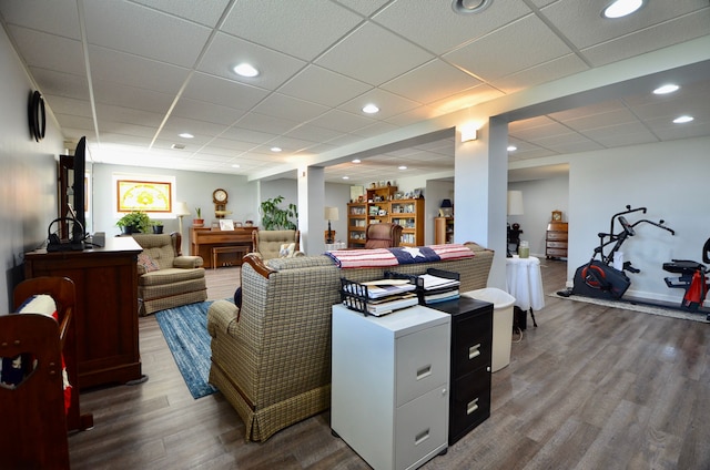 living room with recessed lighting, a paneled ceiling, and wood finished floors