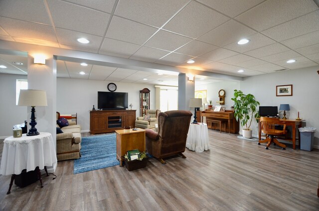 living area featuring recessed lighting, wood finished floors, and a drop ceiling