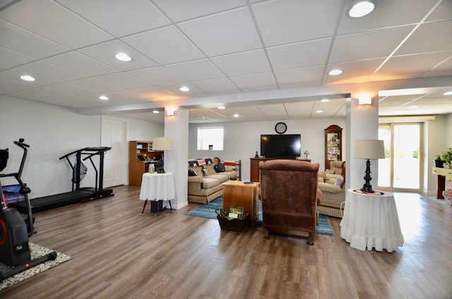 living area featuring wood finished floors, a healthy amount of sunlight, and a paneled ceiling