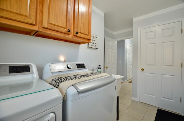 laundry room featuring light tile patterned floors, cabinet space, crown molding, and washing machine and dryer