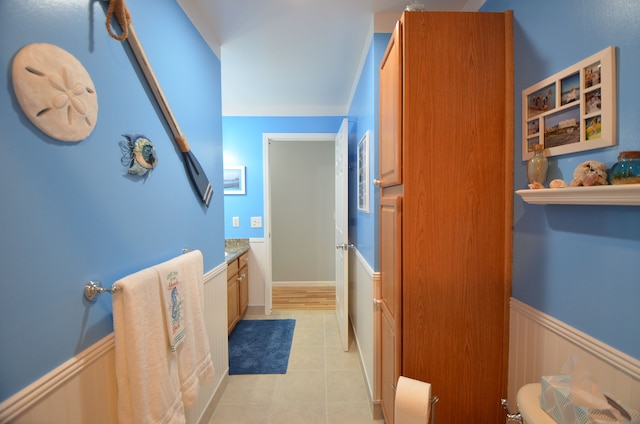 bathroom with tile patterned floors, wainscoting, and vanity