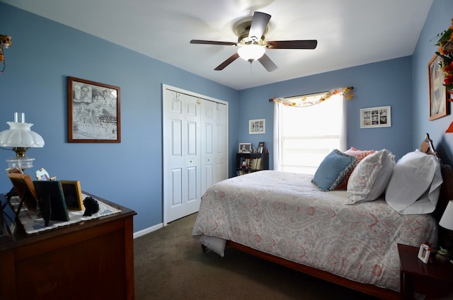 bedroom with baseboards, dark carpet, a ceiling fan, and a closet