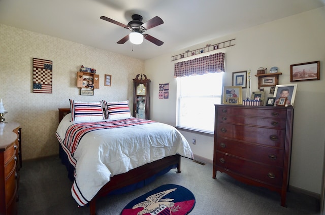 carpeted bedroom with baseboards, wallpapered walls, and ceiling fan