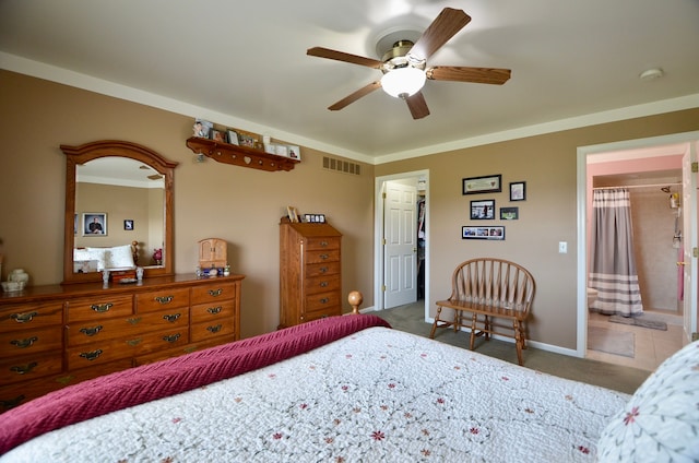 bedroom featuring carpet flooring, visible vents, ensuite bathroom, a ceiling fan, and a walk in closet