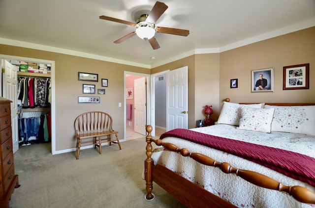 carpeted bedroom with ceiling fan, a spacious closet, a closet, and baseboards