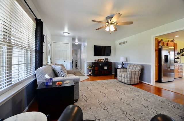 living area with visible vents, a ceiling fan, and light wood-style flooring