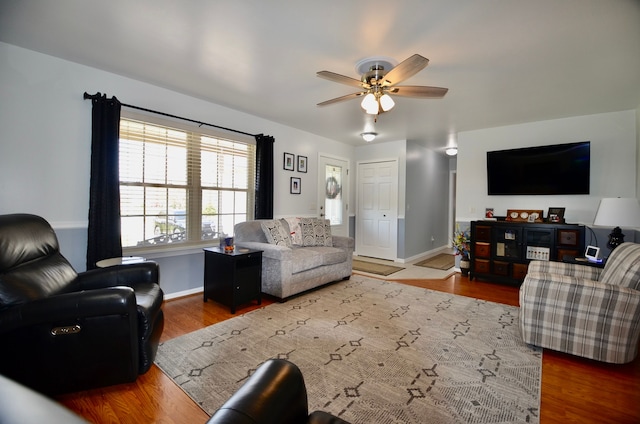 living area featuring wood finished floors, ceiling fan, and baseboards