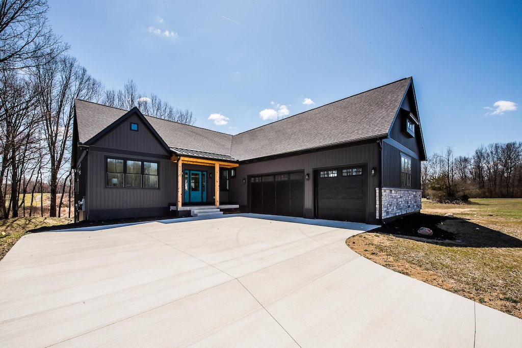 view of front of home featuring concrete driveway, a shingled roof, and an attached garage