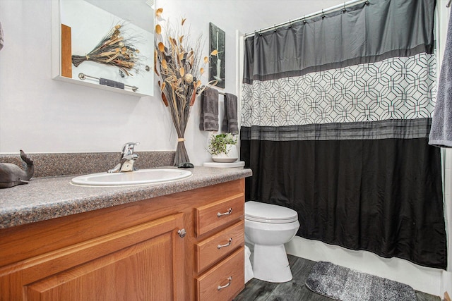 full bathroom featuring a shower with shower curtain, toilet, wood finished floors, and vanity