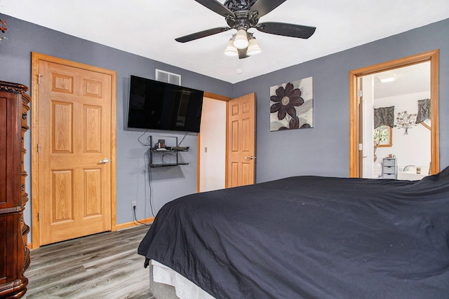 bedroom featuring baseboards, visible vents, wood finished floors, and a ceiling fan