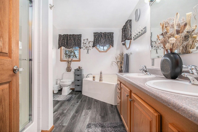 full bath with a bath, double vanity, a sink, and wood finished floors
