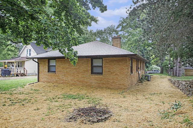 904 W Walnut St, Hastings, MI 49058 - view of side of property with a chimney, brick siding, roof with shingles, and a lawn