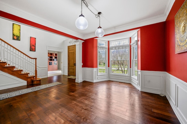 1249 Lasalle Rd, Canton, MI 48187 - unfurnished dining area featuring ornate columns, wood-type flooring, a wainscoted wall, stairway, and ornamental molding