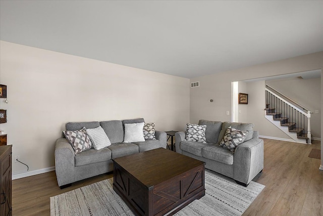 251 Dorsey St, Romeo, MI 48065 - living room featuring stairs, visible vents, baseboards, and light wood-type flooring