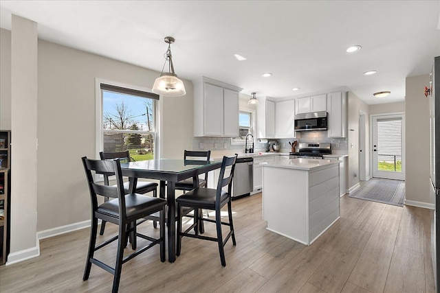 251 Dorsey St, Romeo, MI 48065 - kitchen featuring decorative backsplash, appliances with stainless steel finishes, light countertops, a kitchen island, and baseboards