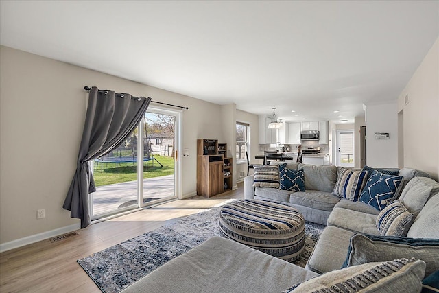 251 Dorsey St, Romeo, MI 48065 - living room featuring baseboards, visible vents, and light wood finished floors