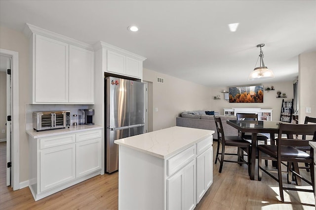 251 Dorsey St, Romeo, MI 48065 - kitchen with freestanding refrigerator, a toaster, a fireplace, light wood finished floors, and visible vents