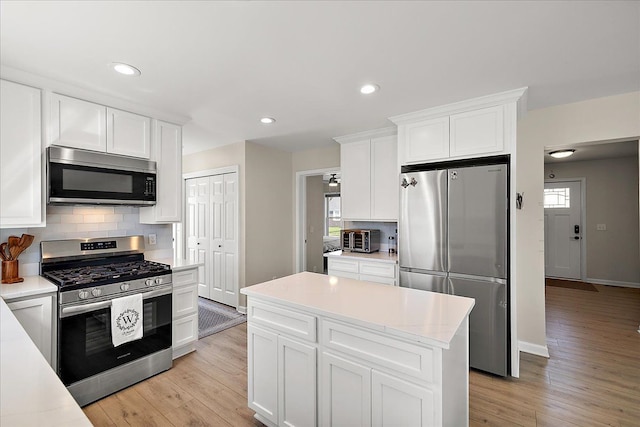 251 Dorsey St, Romeo, MI 48065 - kitchen with light wood-style floors, white cabinetry, stainless steel appliances, and tasteful backsplash