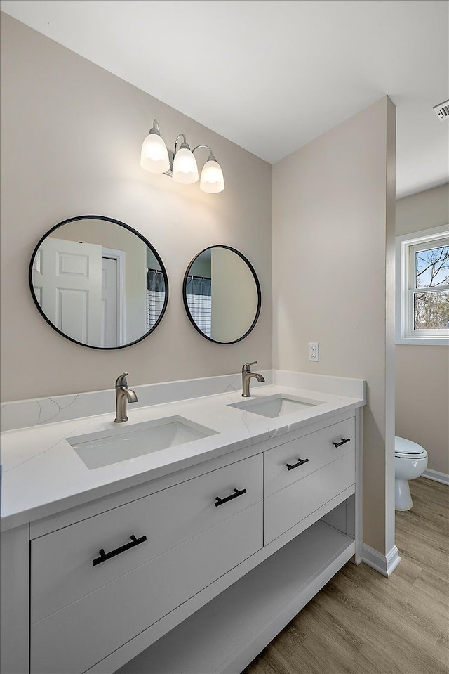 251 Dorsey St, Romeo, MI 48065 - full bath featuring toilet, double vanity, a sink, and wood finished floors