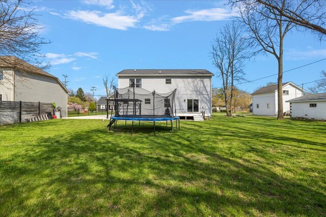 251 Dorsey St, Romeo, MI 48065 - back of house featuring a trampoline, fence, and a yard