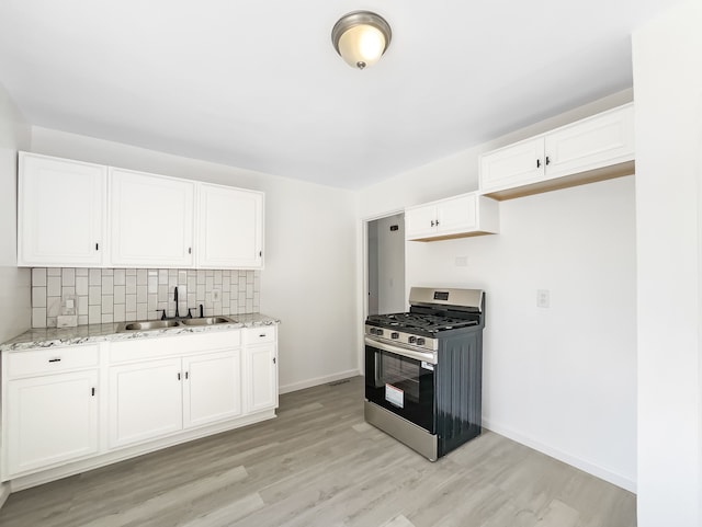 20612 Kingsville St, Harper Woods, MI 48225 - kitchen with light stone countertops, a sink, light wood finished floors, stainless steel range with gas cooktop, and backsplash