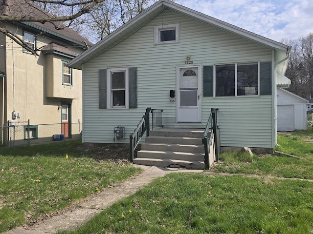 bungalow featuring a front yard and fence