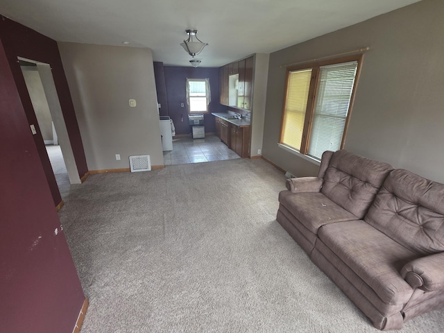 living room with visible vents, light colored carpet, and baseboards