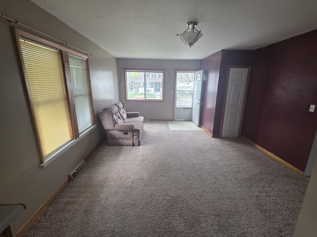 living area featuring visible vents, baseboards, and carpet floors