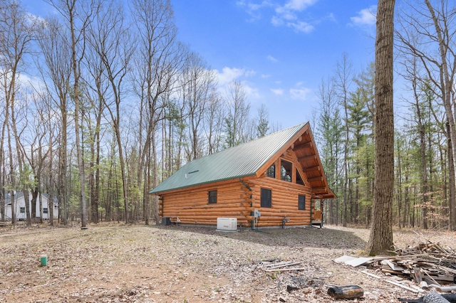 view of side of property featuring metal roof and log exterior