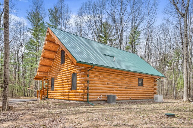 view of home's exterior featuring metal roof, cooling unit, and log siding