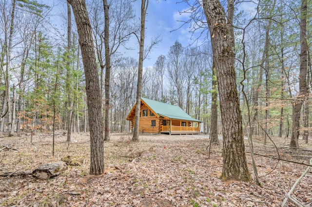 view of home's exterior with a deck, metal roof, and log exterior