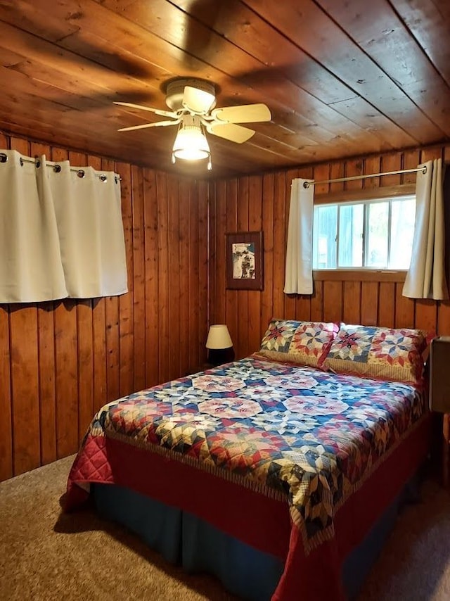 carpeted bedroom with wood walls and wooden ceiling