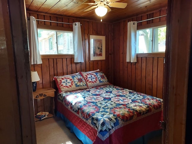 bedroom featuring wooden walls, multiple windows, and wooden ceiling